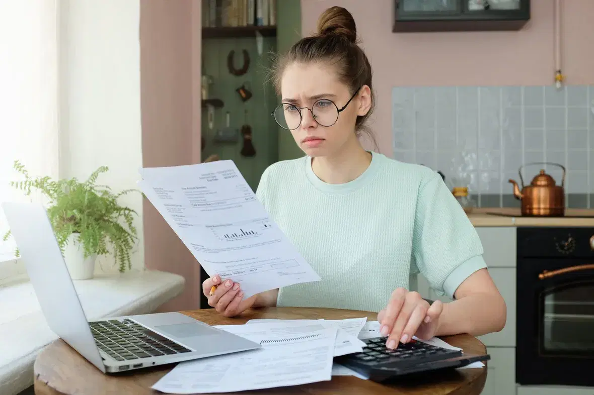 Mujer estresada con finanzas personales entiende su situación financiera con Informe Comercial Califix